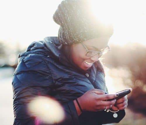 A woman looks at a app on her phone.