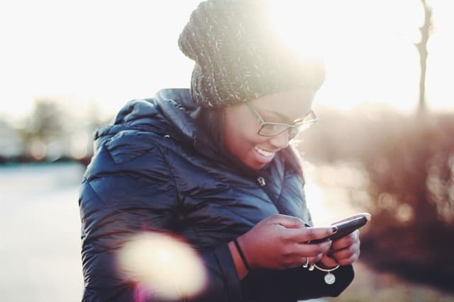 A woman looks at a app on her phone.