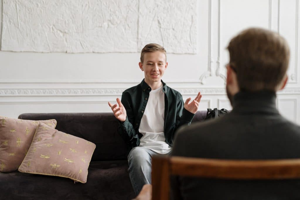 Teenage boy in therapy session with counsellor.