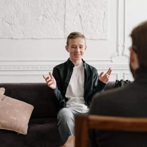 Teenage boy in therapy session with counsellor.