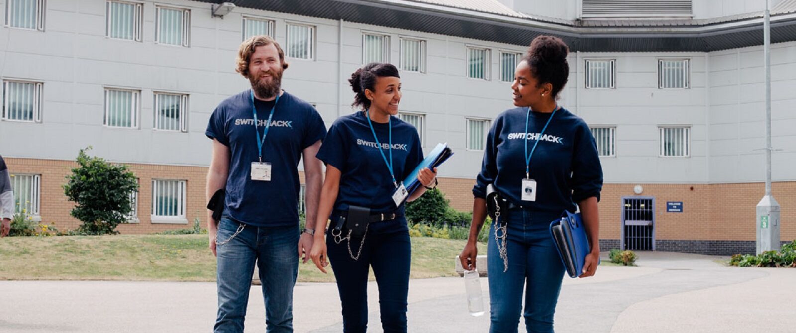 Three charity workers from Switchback walk through a courtyard. Switchback is a London-based charity that support young men to find a way out of the criminal justice system and build stable and rewarding lives.