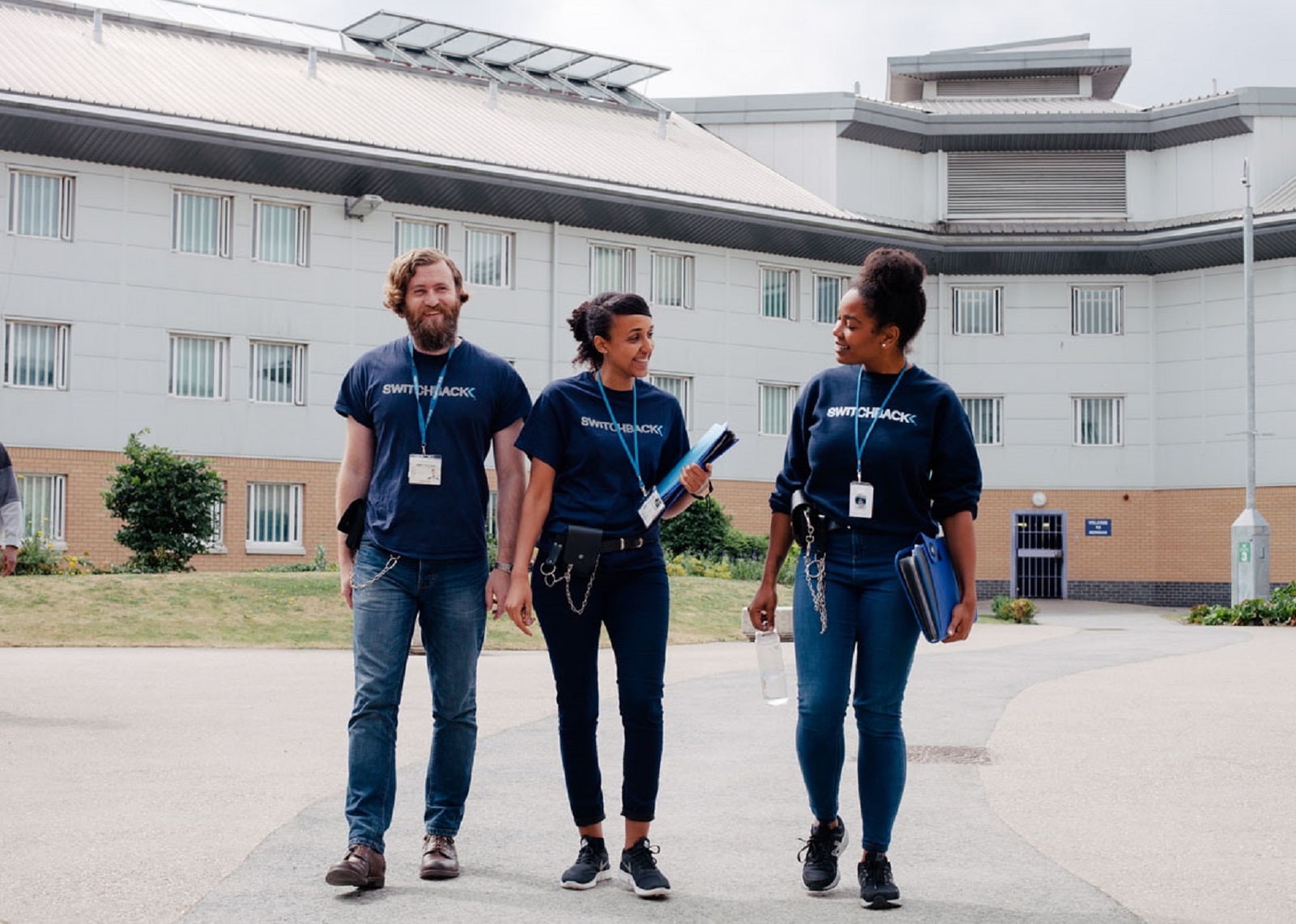 Three charity workers from Switchback walk through a courtyard. Switchback is a London-based charity that support young men to find a way out of the criminal justice system and build stable and rewarding lives.